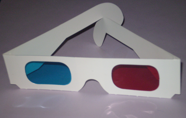 [Photograph of a pair of plastic anaglyph glasses. The right lens in cyan in colour and the left lens is red.]