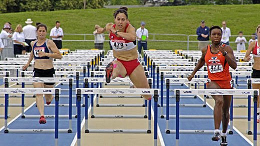 Women compete in the 100m hurdles event