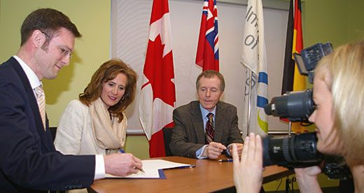 Frank Henning, deputy director of Germany’s Fraunhofer Institute for Chemical Technology, signs a memorandum of understanding to promote research collaboration with the University of Windsor, while Ontario Minister of International Trade and Investment Sandra Pupatello and UWindsor President Alan Wildeman look on
